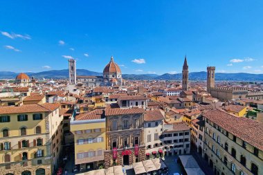 Floransa, İtalya, 11 Mayıs 2024: İkonik duomo katedrali, tarihi şehir binaları ve açık mavi gökyüzü içeren panoramik bir manzara. Canlı ufuk çizgisi ve tarihi mimari bunu seyahat temalı tasarım için mükemmel bir sahne haline getiriyor.
