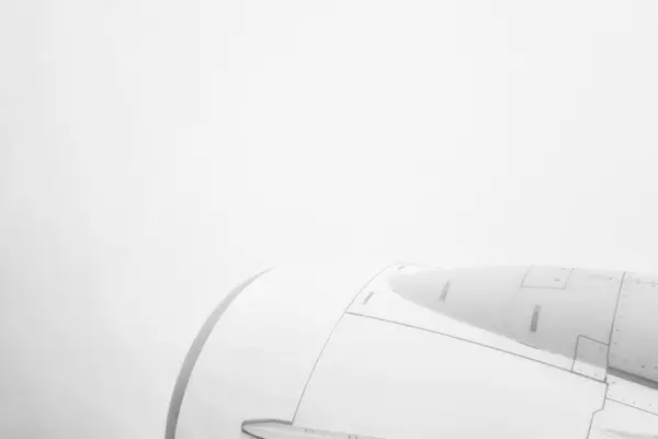 stock image Airplane wing captured during flight through cloudy skies, emphasizing the sleek design and aerodynamics of modern aircraft. ideal for travel and adventure themes, illustrating the journey and exploration aspects of aviation.