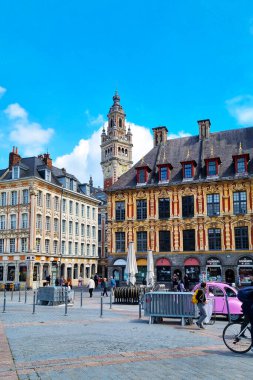 Lille, Fransa, 23 Haziran 2024: Açık bir yaz gökyüzü altında tarihi mimari yapılar ve canlı şehir yaşamının yer aldığı Lille, Fransa 'daki canlı şehir meydanının görüntüsü. Yayalar ve bisikletçiler bu resmedilmeye değer Avrupa 'nın dinamik atmosferine katkıda bulunuyorlar