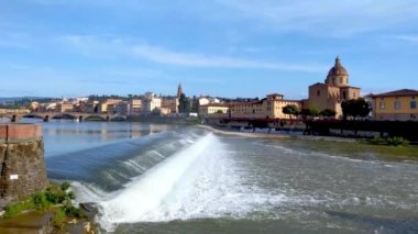 Floransa, İtalya, 10 Mayıs 2024: Floransa 'nın sakin nehir arno' sunun, tarihi binaların ve ikonik mimarinin sergilendiği büyüleyici panoramik manzara. Parlak bir gökyüzü altında, resim gibi.