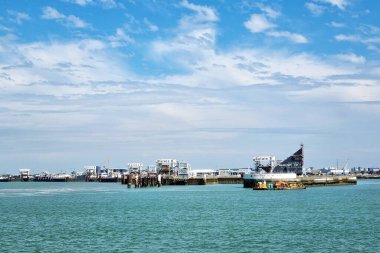Calais, Fransa, 22 Haziran 2024: Açık mavi sularla güneşli bir gökyüzü altında Calais Limanı. çeşitli feribot terminalleri, kenetlenmiş feribotlar ve endüstriyel yapılar görülebilir. Seyahat, ulaşım, deniz sanayisi ve s çevresindeki temalar için uygun