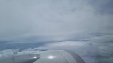 Uçsuz bucaksız gökyüzü ve bulutların büyüleyici hava görüntüsü bir uçak penceresinden çekildi. Uçağın gösterişli kanadı ve motoru seyahat, havacılık ve seyahat tutkusu temaları için mükemmel bir hareket ve macera duygusu sağlıyor..