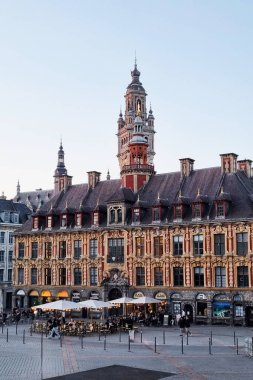 Lille, France, June 23, 2024: Historic architecture in lille features ornate buildings with a towering belfry overlooking a charming cafe terrace. the scene essence of european travel destinations with its blend of culture and historical significance clipart