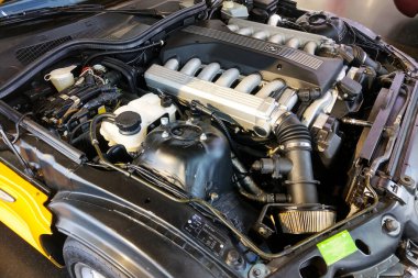 Münih, Almanya, 25 Ağustos 2024: Çeşitli bileşenleri ve sistemleri gösteren yüksek performanslı bir otomobil motorunun ayrıntılı bir görüntüsü. Oto tamircileri, hevesliler ve eğitim amaçları için ideal. Modern otomobilin karmaşıklığını ve mühendisliğini vurguluyor