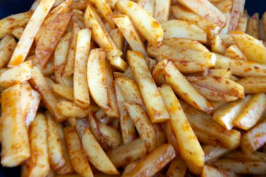 Lezzetli baharatlı baharatla kaplanmış, çıtır çıtır, altın patates kızartması. Her kızartma rengini ve çekiciliğini arttıran mükemmel bir baharat karışımı sergiler. Gıda içeriği, aşçılık blogları veya abur cubur reklamları için ideal.