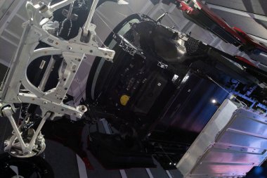 Münih, Almanya, 25 Ağustos 2024: Gelişmiş süspansiyon sistemi bileşenleri ve yapısal elementlerin yer aldığı modern bir araba şasesinin ayrıntılı görünümü. Çağdaş otomobil üretiminde kullanılan hassas mühendislik ve yenilikçi tasarımı vurgular