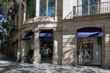 Barcelona, İspanya, 1 Ekim 2024: Mimari zarafet lüks modayla harmanlanmış üst düzey bir Ralph Lauren mağazasında. Doğal ışık klasik tasarım ve şık gösterileri vurgular, moda meraklılarını zamansız koleksiyonları keşfetmeye davet eder