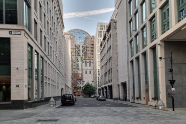 Londra, Birleşik Krallık, 28 Haziran 2024: Modern ve tarihi mimarinin bir karışımının yer aldığı bir sokak sahnesi. Uzun, gösterişli binalar cadde boyunca uzanır. Gözü merkezdeki daha eski bir yapıya götürür. bu kombinasyonda kentsel gelişim ve