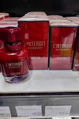 Girona, İspanya, 5 Ekim 2024: Zarif kırmızı ambalajını sergileyen givenchy parfüm perakende rafında sergilenmektedir. Düzenleme lüks kokuları vurguluyor, müşterileri premium eau de parfum 'u keşfetmeye davet ediyor.