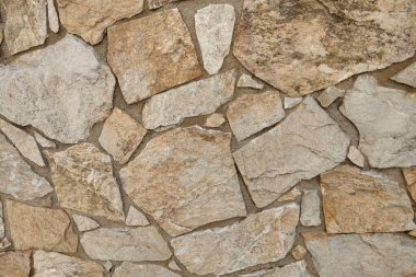 Kırsal taş duvar, bej ve kahverengi tonlarında desenli fayanslar sergiliyor. Mimari tasarım, geçmiş ve inşaat projeleri için mükemmel, doğal ve dünyevi bir estetik sunuyor..