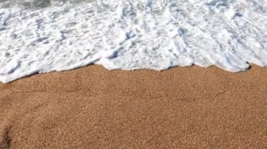 Yumuşak okyanus dalgaları sıcak, altın kumlu plajla buluşur ve sakin bir atmosfer yaratır. Fotoğrafçılıkta tatil rahatlama, doğa güzelliği veya kıyı tasarımı temalarını tasvir etmek için ideal