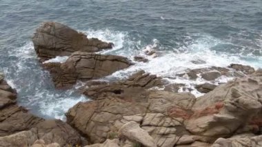 Dalgalar engebeli kıyı kayalarına çarpar ve sakin bir deniz manzarası yaratır. Kayaların dokusu ve okyanusun dinamik hareketi sakin ama güçlü bir doğal sahne sunuyor. Tasarımlar için mükemmel.