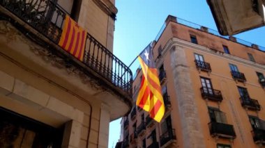 Girona, İspanya, 3 Ekim 2024: Katalonya bağımsızlık bayraklarıyla süslenmiş kentsel sokaklar bölgesel gurur gösteriyor. Canlı kırmızı ve sarı çizgiler kültürel kimliği sembolize ediyor.