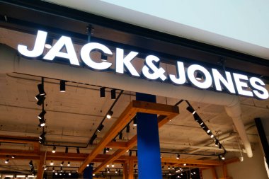 Barselona, İspanya, 3 Ocak 2025: Bir alışveriş merkezinin perakende satış mağazasının girişinde Jack Jones tabelası aydınlatılmış. Modern tasarım, tavan borularını aydınlatarak çağdaş ve davetkar bir atmosfer yaratıyor..