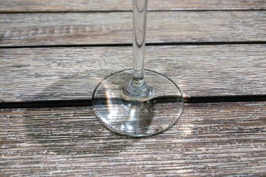 Zarif cam kadehler, kırsal ahşap bir masa yüzeyiyle güzel bir tezat oluşturarak sofistike bir yemek sahnesi oluşturuyor. Işık ve gölgenin etkileşimi dokuyu geliştirir, zarafet ve stil kavramları için mükemmeldir..