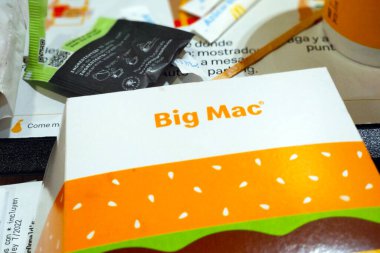 Barselona, İspanya, 26 Aralık 2024: Tepside büyük mac ambalaj seti, fast food kültürü ve markalaşma. Kompozisyon, çeşitli tanıtım materyalleri içeren ve kolaylık ve yemek eğilimlerine odaklanan bir yemek ortamının unsurlarını içerir..