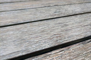 Weathered wooden deck planks display a natural texture with visible grain patterns and subtle color variations. the close-up perspective highlights the aging process of the wood, creating a rustic and organic appearance. clipart