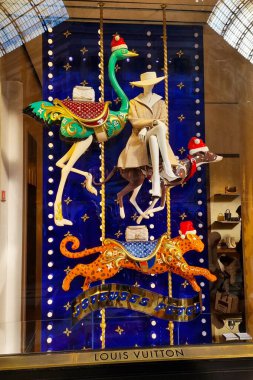 Milan, İtalya, 1 Aralık 2024: Bir Louis Vuitton mağazasında canlı ve yaratıcı bir vitrin gösterisi tatil temalı öğeler sergiliyor. Özellikleri arasında renkli bir devekuşu, bir ren geyiği köpeği ve göz kamaştırıcı bir şeye karşı hazırlanmış bir çita sallanan atı yer alıyor.
