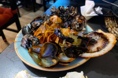 Ağız sulandıran deniz ürünleri makarnası çeşitli kabuklu deniz ürünleri ile süslenir, midye, karides ve deniz tarağı dahil. Gurme yemek deneyimi ya da yemek fotoğrafçılığı projeleri arayan aşçılar için mükemmel..