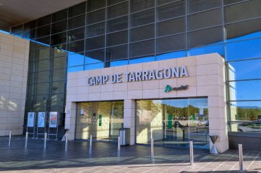 Tarragona, İspanya, 30 Aralık 2024: Tarragona kampının girişi büyük cam pencereli ve gösterişli cepheli modern mimari tasarımı sergiliyor. Simetrik yapı, natur tarafından vurgulanan ulaşım merkezini vurgular