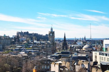 Edinburgh, İskoçya, 1 Nisan 2025: İkonik kalesini, tarihi saat kulesini ve açık mavi gökyüzü altında çeşitli mimari gökyüzünü gösteren manzaralı bir manzara. Bu resim, kentteki antik ve modern yapıların karışımını vurgular.