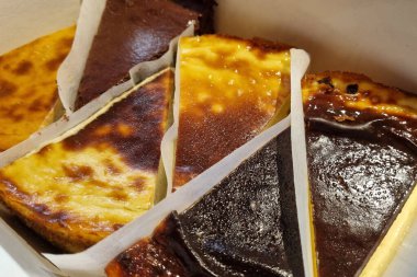 Peynirli kek dilimleri, pürüzsüz dokular ve altın kahverengiden koyu çikolataya bir dizi zengin malzemeler, tatlı için mükemmel aşermeler ve tatlı sunumları..