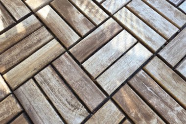 Kare ahşap karolardan oluşan geometrik düzenleme modern iç tasarım, döşeme ve mimari elementler için uygun iç içe geçmiş bir model oluşturuyor. Doğal ahşap tonlarının karışımı doku ve sıcaklık ekler..