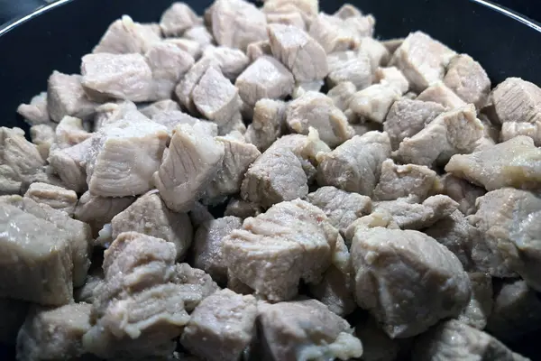 Küplerce pişmiş domuz eti siyah bir tavada sergilenir, çeşitli mutfak uygulamaları için idealdir. Yumuşak et, lezzetli tarifleri, yemek hazırlıklarını ve gıda tasarım projelerini geliştirmek için mükemmel bir dokuya sahiptir..