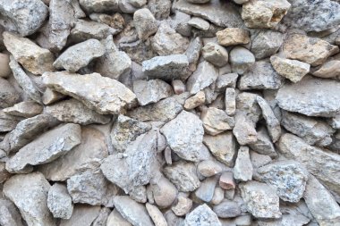 Yıpranmış gri taşlar doğal bir şablonda dizilmiş arka plan, tasarım projeleri veya inşaat temaları için dokulu bir yüzey yaratırlar. organik şekiller ve taş boyutlarının çeşitleri görsel ilgi yaratıyor..