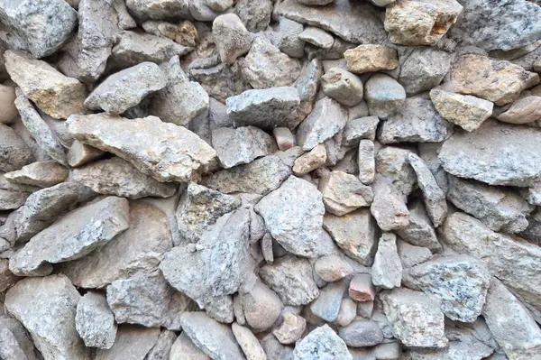 Yıpranmış gri taşlar doğal bir şablonda dizilmiş arka plan, tasarım projeleri veya inşaat temaları için dokulu bir yüzey yaratırlar. organik şekiller ve taş boyutlarının çeşitleri görsel ilgi yaratıyor..