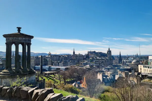 Edinburgh, İskoçya, 1 Nisan 2025 Calton Hill 'den Edinburgh' un panoramik manzarası şehrin ikonik ufuk çizgisini gösteriyor. Sahne, tarihi mimari, yuvarlanan tepeler ve seyahat ve mimarlık meraklıları için mükemmel mavi bir gökyüzünü içeriyor..