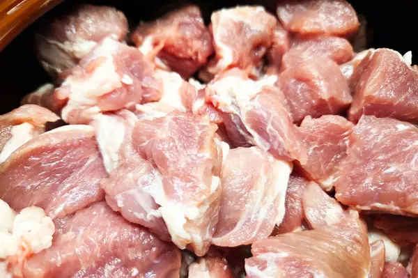 Pişirme hazırlıkları için ideal taze çiğ domuz parçaları yakın plan görüntüsü. Pembe ve beyaz mermer kalitesini gösteriyor, onu çeşitli tarifler ve mutfaklardaki mutfak uygulamaları için uygun hale getiriyor..