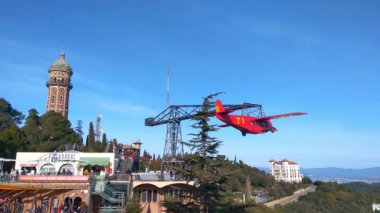 Barselona, İspanya, 2 Ocak 2025: Tibidabo eğlence parkının üzerinde berrak mavi gökyüzü ve tarihi mimari zeminine karşı canlı bir vintage uçak havada süzülüyor. Barselona 'daki eğlence ve kültür mirasının bir karışımı..
