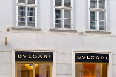 Viyana, Avusturya, 5 Mayıs 2025: Bvlgari butik mağaza vitrininde zarif mimari ayrıntılar sergilenmektedir. Lüks markaların tabelaları şık bir şehir geçmişine karşı belirgin bir şekilde sergileniyor, şehir yaşamındaki son moda ve entelektüelliği yansıtıyor..