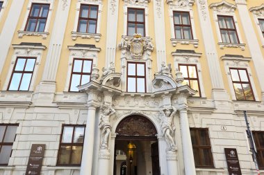 Viyana, Avusturya, 3 Mayıs 2025: Karmaşık oymalar, büyük giriş ve simetrik pencerelerin yer aldığı tarihi barok bina cephesi. Süsleme sanatsal ayrıntıları vurguluyor, mimari çalışmalar, seyahat broşürleri ve kültürel kaşifler için uygun