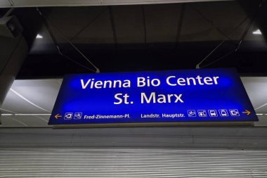 Viyana, Avusturya, 4 Mayıs 2025: Viyana biyoloji merkezi St. Marx 'ın aydınlatılmış işareti, net yön göstergeleri gösteriyor. Mavi tabela, ziyaretçilere önemli kentsel bilimler ve ulaşım merkezlerine rehberlik eden bir gece ortamında göze çarpıyor..