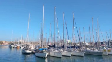 Barcelona, Spain, December 25, 2024: Tranquil Marina with Sailboats on a Clear Blue Day - Perfect for Nautical Posters and Travel Designs
