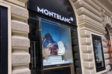 Viyana, Avusturya, 5 Mayıs 2025: Montblanc mağaza vitrininde çarpıcı bir dağ zeminine karşı lüks bir çanta ve sofistike bir vitrin sergileniyor. Şık bir şehir ortamında kurulmuş, modayı ve seyahatleri hedef alan rafine tasarımı vurguluyor