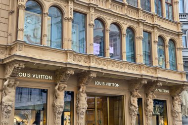 Viyana, Avusturya, 5 Mayıs 2025: Tarihi, karmaşık tasarlanmış bir binada lüks moda mağazası önü. Süslü mimaride ayrıntılı oymalar, büyük pencereler ve klasik heykeller yer alıyor, yüksek moda ve klasik Desi 'nin füzyonunu sergiliyorlar.