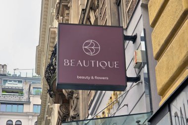 Viyana, Avusturya, 5 Mayıs 2025: 'Güzellik' tabelası modern bir bina cephesinde 'güzellik çiçekleri' yazılı zarif bir tasarıma sahip. kentsel mimari öğeler çağdaş işareti çerçevelediler, sofistike bir alışveriş uzmanına işaret ediyor