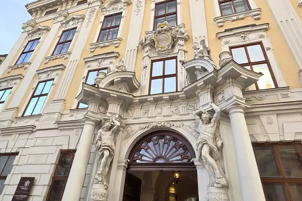 Viyana, Avusturya, 3 Mayıs 2025: Karmaşık heykeller ve klasik sütunlarla süslenmiş bir barok tarzı binanın ayrıntılı bir görüntüsü. Mimari ayrıntılar tarihi tasarımın ihtişamını ve sanatsal zarafetini yansıtır..