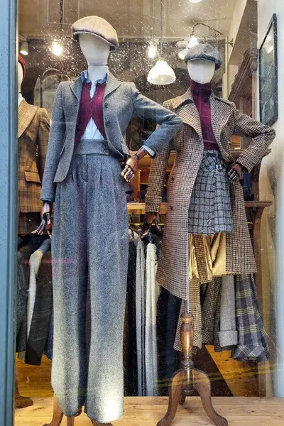 Edinburgh, İskoçya, 29 Mart 2025: Tüvit ceketler ve ekose eteklerin yer aldığı mağaza vitrinli eski moda kıyafetler. Klasik tasarım, sonbahar moda eğilimlerini vurguluyor, nötr tonlar ve zamansız modellerle zarafet yayıyor.