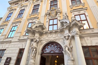 Viyana, Avusturya, 3 Mayıs 2025: Karmaşık heykeller ve klasik sütunlarla süslenmiş bir barok tarzı binanın ayrıntılı bir görüntüsü. Mimari ayrıntılar tarihi tasarımın ihtişamını ve sanatsal zarafetini yansıtır..