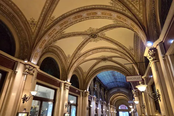 Viyana, Avusturya, 3 Mayıs 2025: Süslü mimari öğeler, karmaşık biçimde ayrıntılı kemerli tavanlar sergilenen tarihi bir alışveriş salonunu süslüyor. Zarif tasarım dekoratif kalıpları ve antika tarzı ışıklandırmayı içerir, sofistike ve Tim