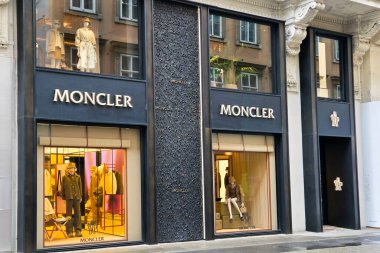 Viyana, Avusturya, 5 Mayıs 2025: Şık lüks moda butiği canlı vitrin vitrinlerinde şık tasarımlar sergiliyor. Zarif mimari, içinde yer alan üst düzey giyim koleksiyonlarını tamamlayarak, davetkar bir alışveriş ortamı yaratıyor.