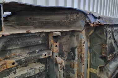 Paslı ve yıpranmış bir arabanın yakın çekim görüntüsü paslanmış metalin dokusunu bozuyor. Katmanlı pas ve ezgi, endüstriyel ve otomotiv temaları için ideal zaman ve pozlama etkilerini ortaya koymaktadır..
