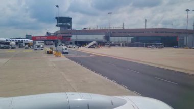 Bologna, İtalya, 9 Mayıs 2024: Terminal ve Uçak Kanadı manzaralı Bologna Havaalanı Asfalt Sahnesi