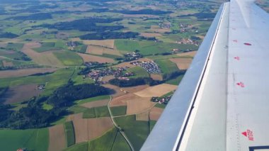 Yeşillik tarım arazilerinin üzerindeki uçak penceresinden kırsal arazinin hava görüntüsü