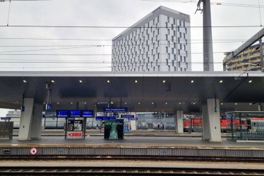 Viyana, Avusturya, 5 Mayıs 2025: Bulutlu bir gökyüzü altında dijital bilgi sergilenen gösterişli bir mimariye sahip modern tren istasyonu. Kentsel seyahat ve bağlantı, toplu taşıma verimliliği ve çağdaş tasarım unsurlarının özünü yakalar.