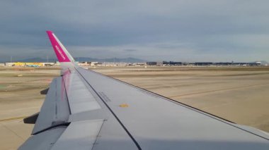 Barselona, İspanya, 4 Ocak 2025: Geniş pisti ve havalimanı altyapısını çevreleyen bir uçak penceresinden hava perspektifi. uçaklar kanat ucu perspektife bağlam ekler